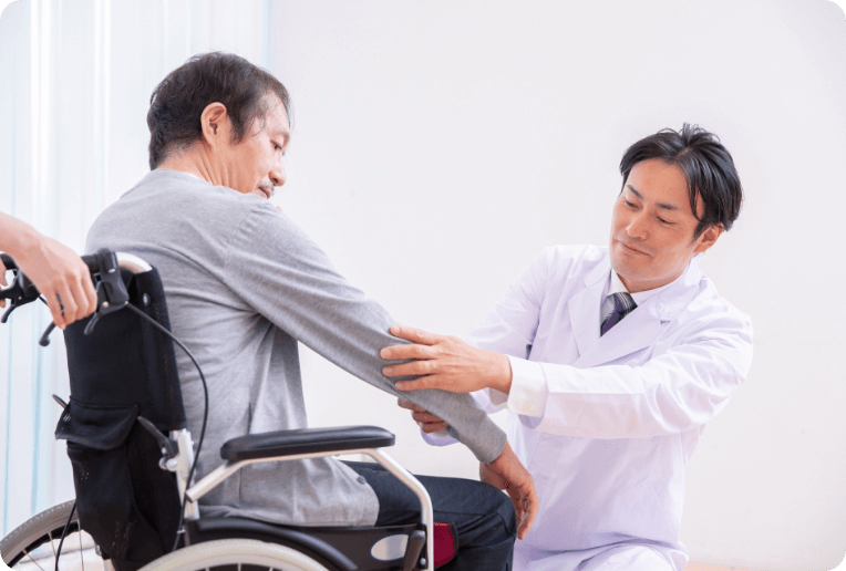 車椅子の患者様に治療を施す医師